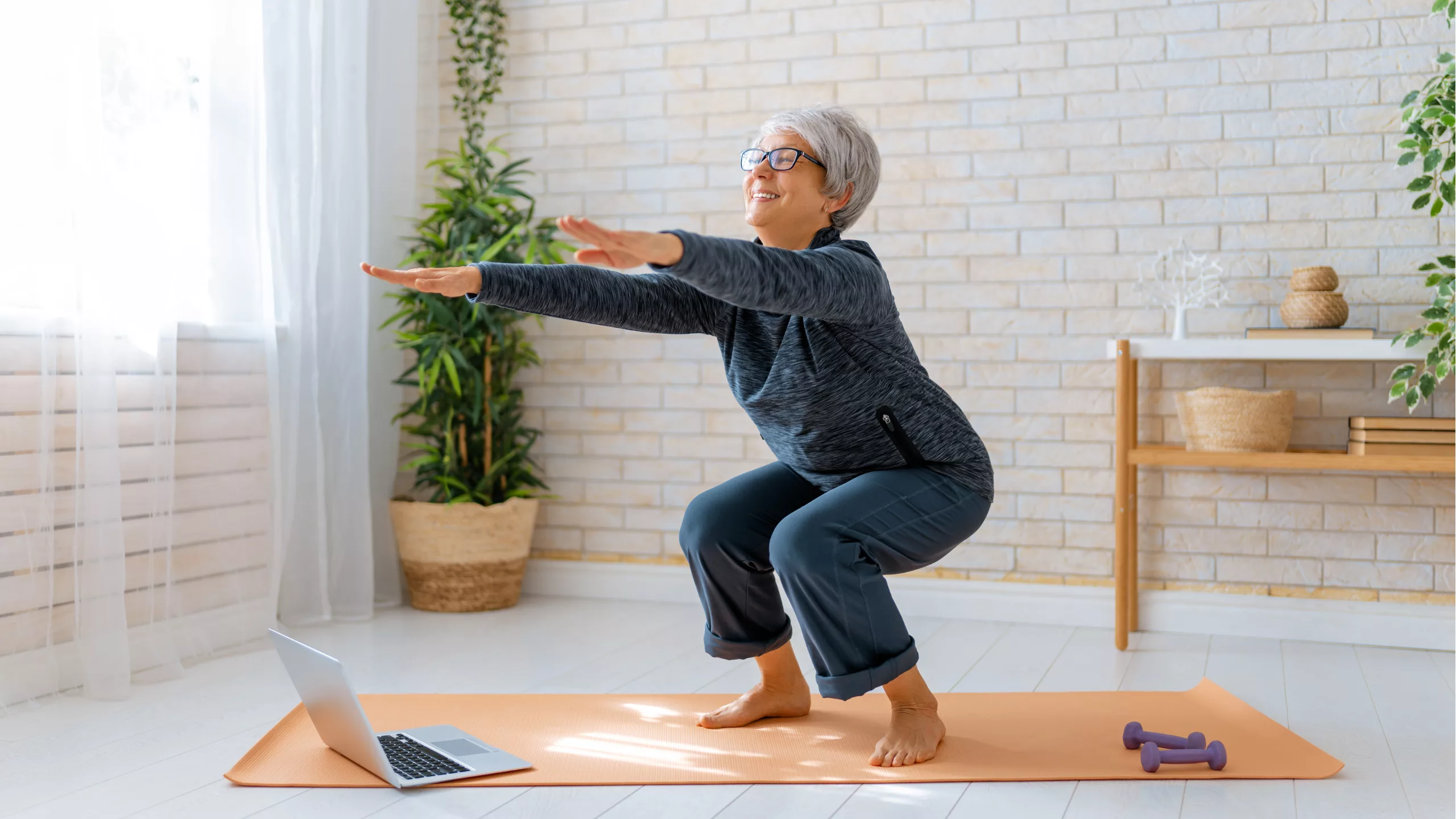 Older lady doing exercise on yoga mat at home.
