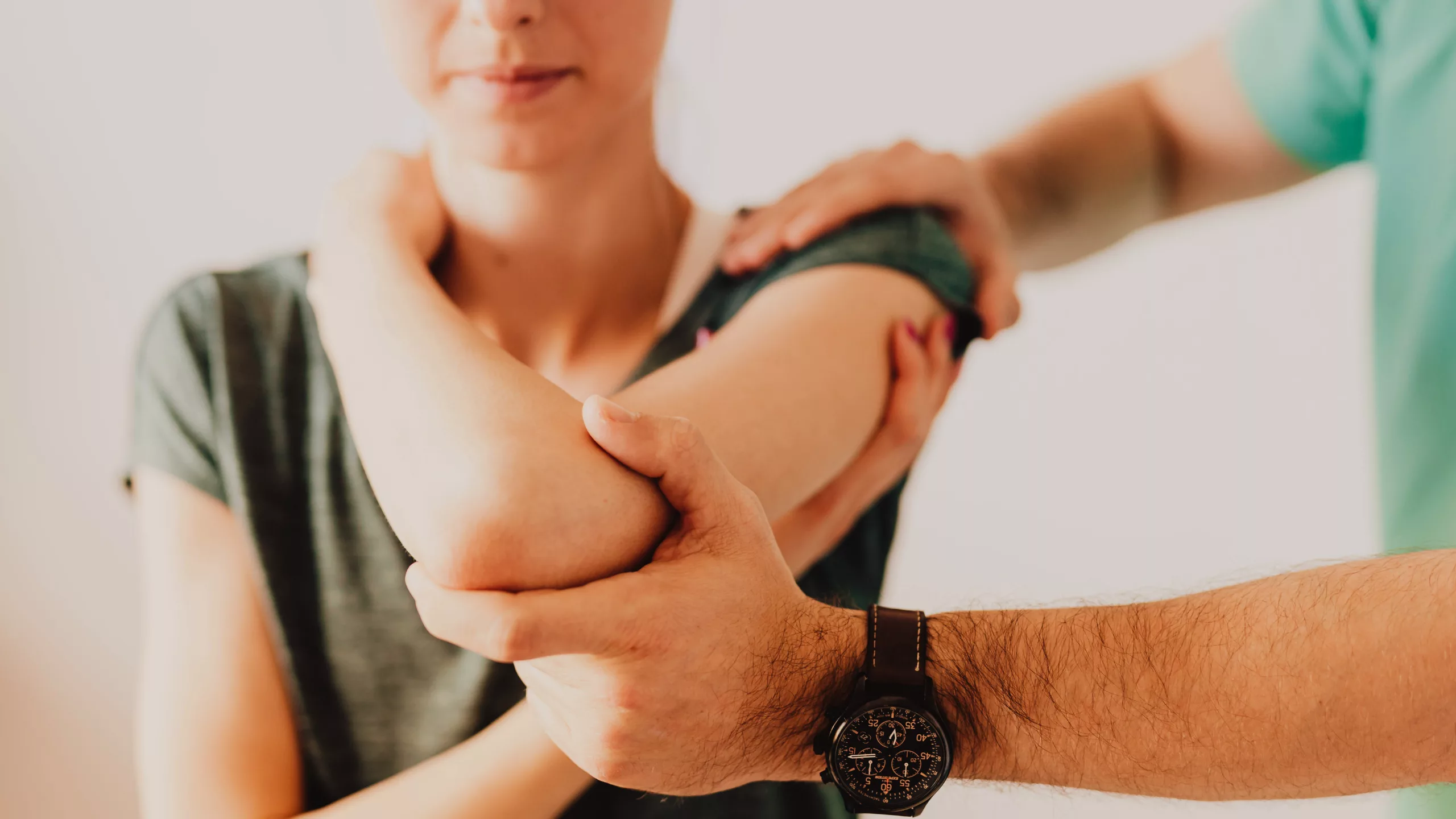 Physio giving early intervention physiotherapy to person with elbow pain